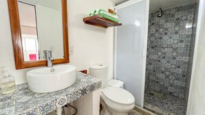 Un bany amb rentapisa, vàter i plat de dutxa.