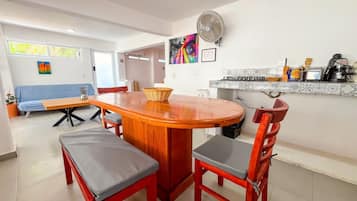 A modern kitchen with a wooden dining table, chairs, and a built-in stove.