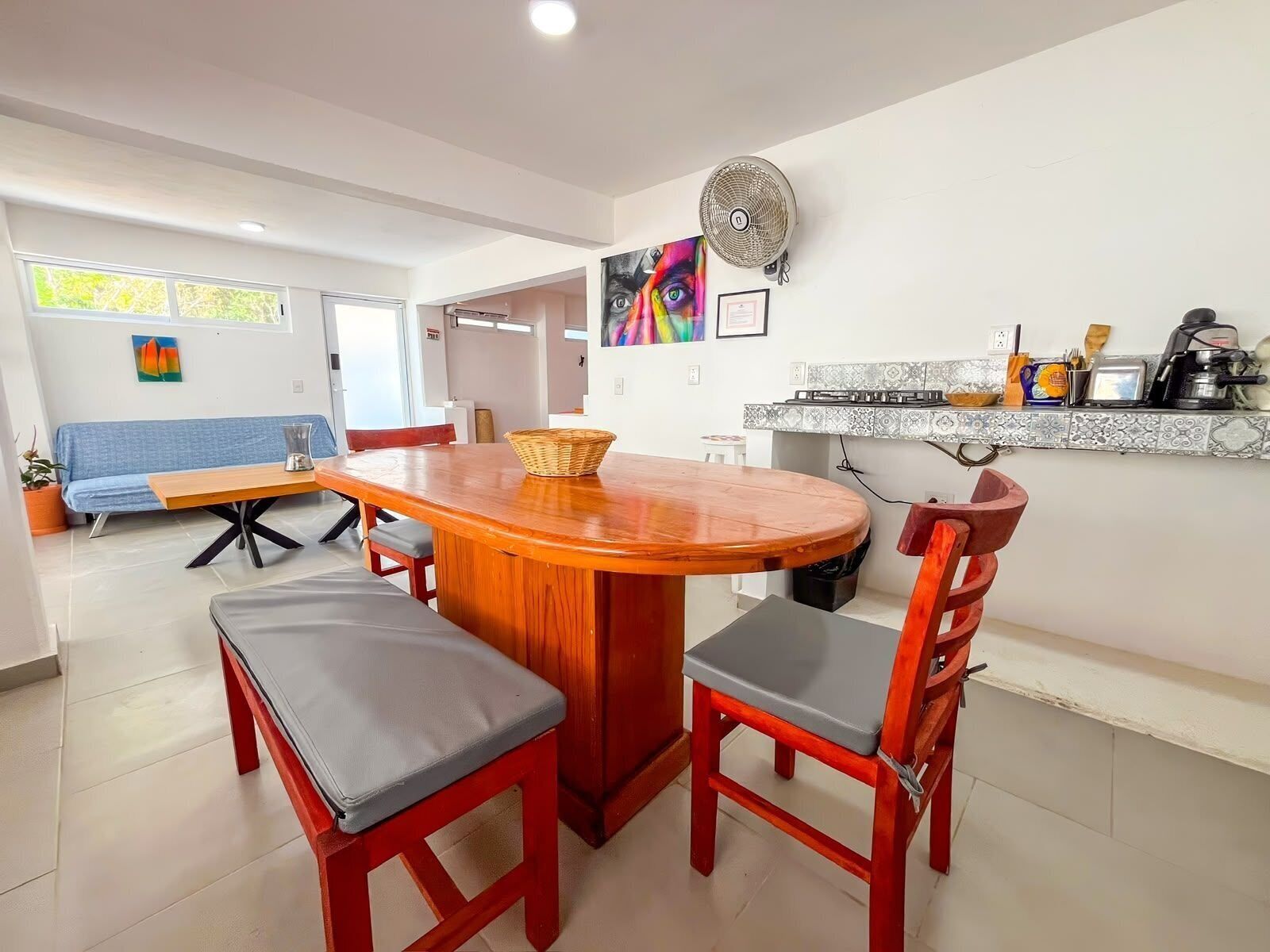 A modern kitchen with a wooden dining table, chairs, and a built-in stove.