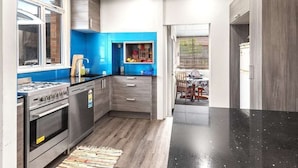 A modern kitchen with a gas stove, oven, and blue cabinets. - Cozy 4 bedrooms House BNB at Whangarei Town center. Next to supermarket/ schools (Whangārei)
