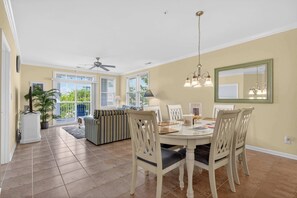 A dining area with a round table, chairs, a ceiling fan, and a large window. - 6 Sunset Island Drive 3F (Ocean City)