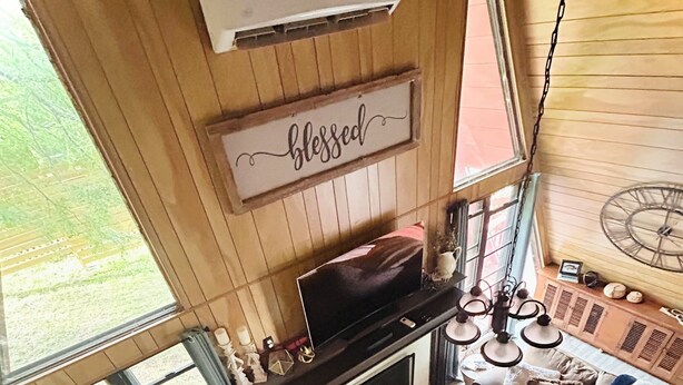 Un salon chaleureux avec une cheminée, un téléviseur et un coin salon confortable.
