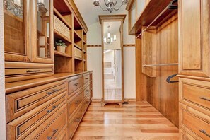 A wooden hallway with built-in cabinetry, a chandelier, and a mirror. - Fossil Run! Curated Home w/ Wellness & Game Room (Colorado Springs)