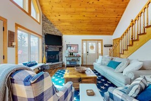 Ein gemütliches Wohnzimmer mit Kamin, Holzboden und einer Treppe.