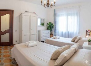 A hotel room with two beds, a wardrobe, a desk, and a chandelier. - Holiday apartment with balcony (Poggi Inferiore Poggi Superiore)