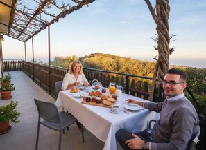 A terrace with a table set for breakfast, overlooking a scenic landscape. - Holiday apartment with balcony (Poggi Inferiore Poggi Superiore)