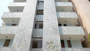 A multi-story hotel with a modern architectural design, featuring a prominent sign with the name 'Hotel Mar Azul' and balconies on each floor. - Hotel Mar Azul by Croma (Santa Marta)