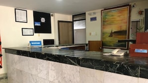 A reception desk with a marble counter, a phone, and a sign indicating a reception area. - Hotel Mar Azul by Croma (Santa Marta)