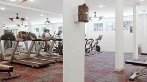 Une salle de sport équipée de tapis de course, de vélos d’appartement et d’autres appareils d’exercice.