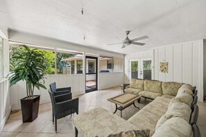 A covered patio with a ceiling fan, a sofa, a table, and a potted plant. - Quiet Neighborhood, Fenced Yard, Dog Friendly (Fernandina Beach)