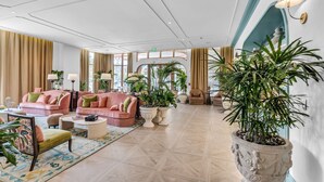 A spacious lobby with a high ceiling, large windows, and a variety of seating arrangements including sofas and chairs. - Luxe Wynwood 1BR · Balcony + Rooftop Pool, Miami (Miami)
