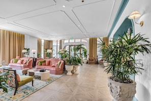 A spacious lobby with a high ceiling, large windows, and a variety of seating arrangements including sofas and chairs. - Luxe NoMad Wynwood 1BR Balcony & Rooftop (Miami)