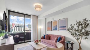 Een moderne woonkamer met een bank, salontafel en potplanten.