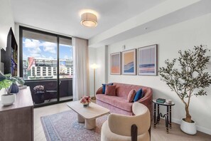 Ein modernes Wohnzimmer mit einer Couch, einem Couchtisch und Topfpflanzen.