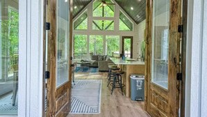 Un interior rústico con techo alto, vigas de madera y ventanas amplias.