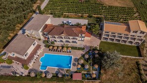A large hotel with a swimming pool, multiple guest rooms, and a landscaped garden. - Grape Vine (Zakynthos)