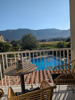A balcony with a view of a swimming pool and mountains. - Grape Vine (Zakynthos)