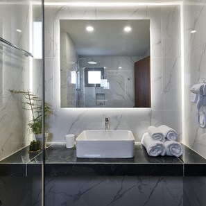A modern bathroom with a large mirror, a rectangular sink, and a towel rack. - Grape Vine (Zakynthos)