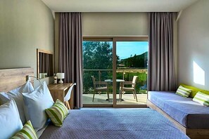 A hotel room with a bed, a desk, a chair, and a balcony with a view. - Grape Vine (Zakynthos)