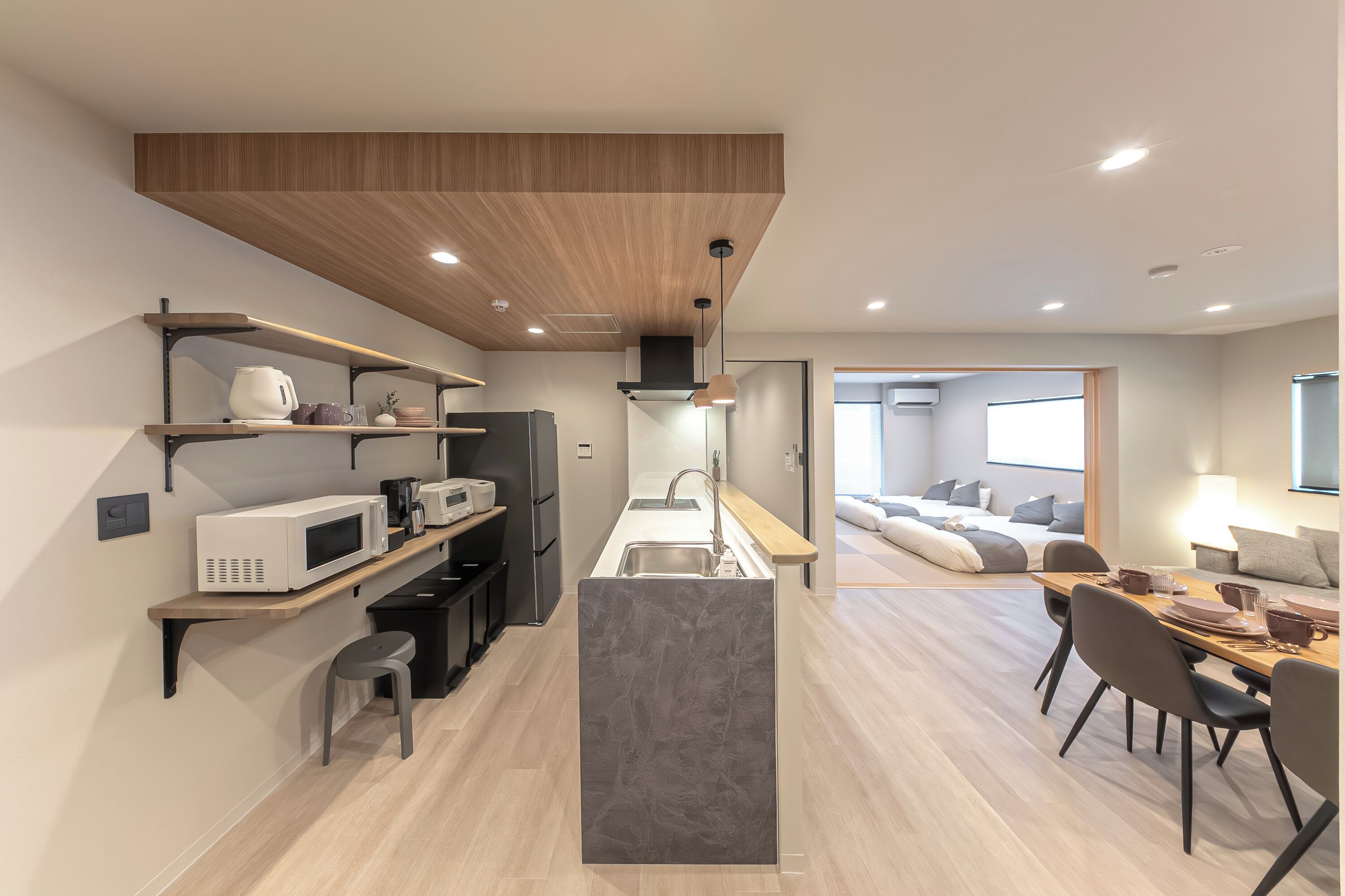 Une cuisine moderne dotée d’un îlot central, d’appareils électroménagers intégrés et d’un coin repas avec une table et des chaises.