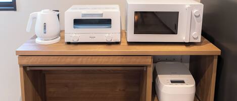 A kitchen counter with a microwave, toaster, and coffee maker.