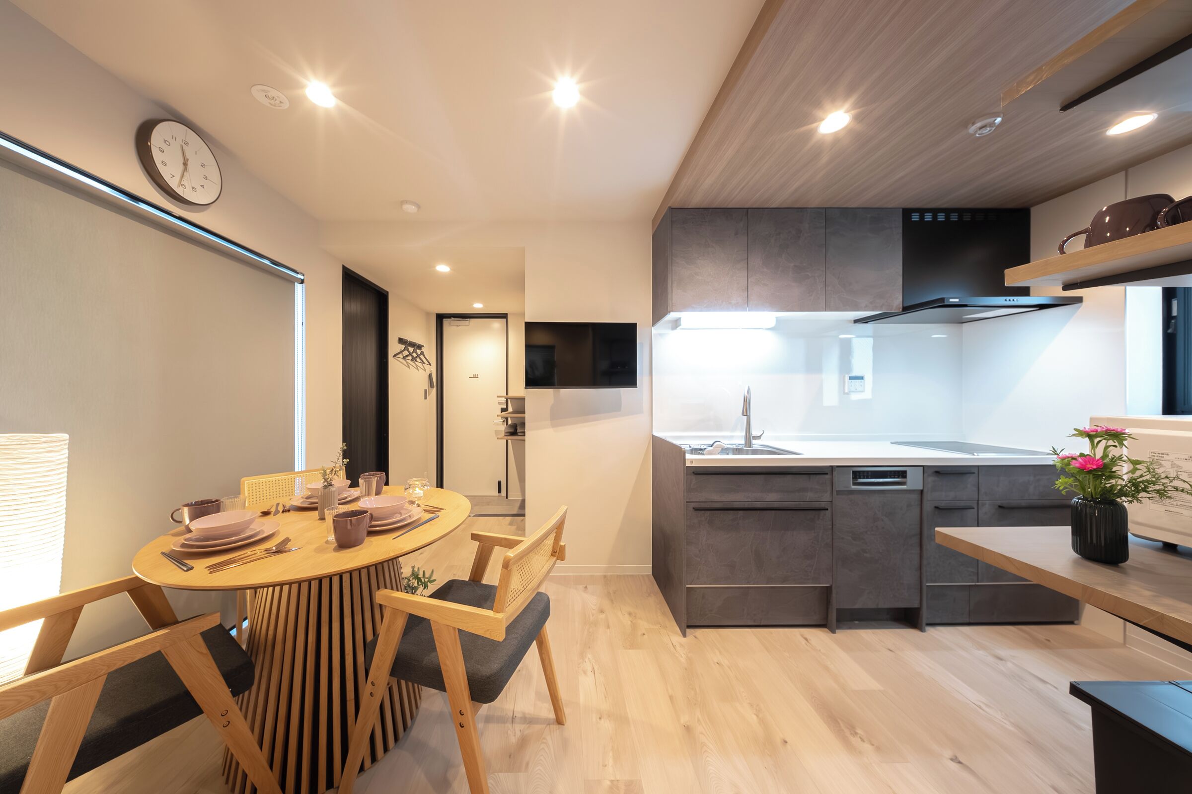 Una cocina moderna con una isla central, electrodomésticos integrados y un comedor con una mesa redonda y sillas.