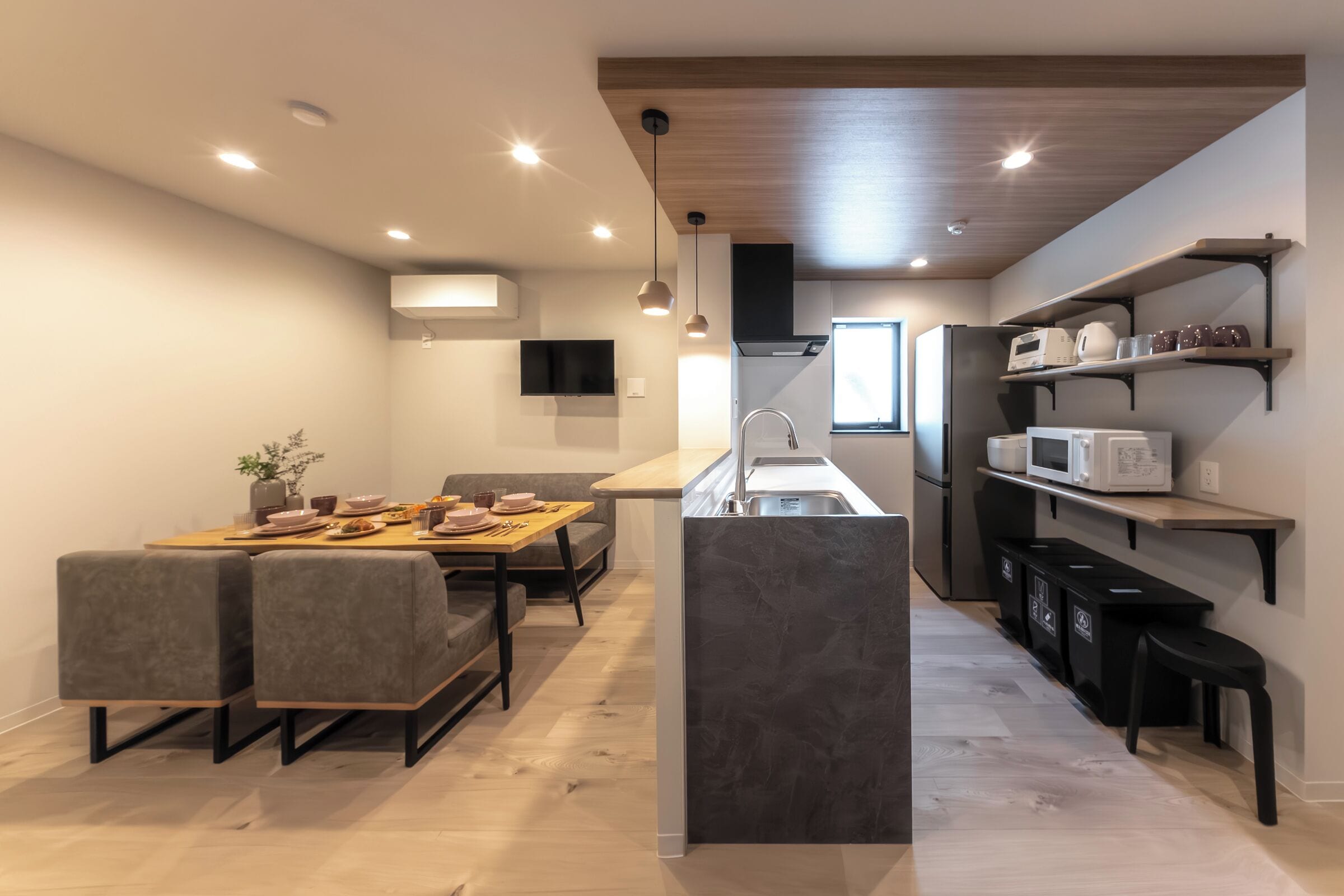 A modern kitchen with a central island, built-in appliances, and a dining area with a table and chairs.