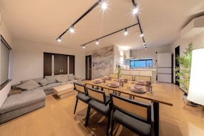 Un comedor moderno con una mesa de madera, sillas y un sofá.