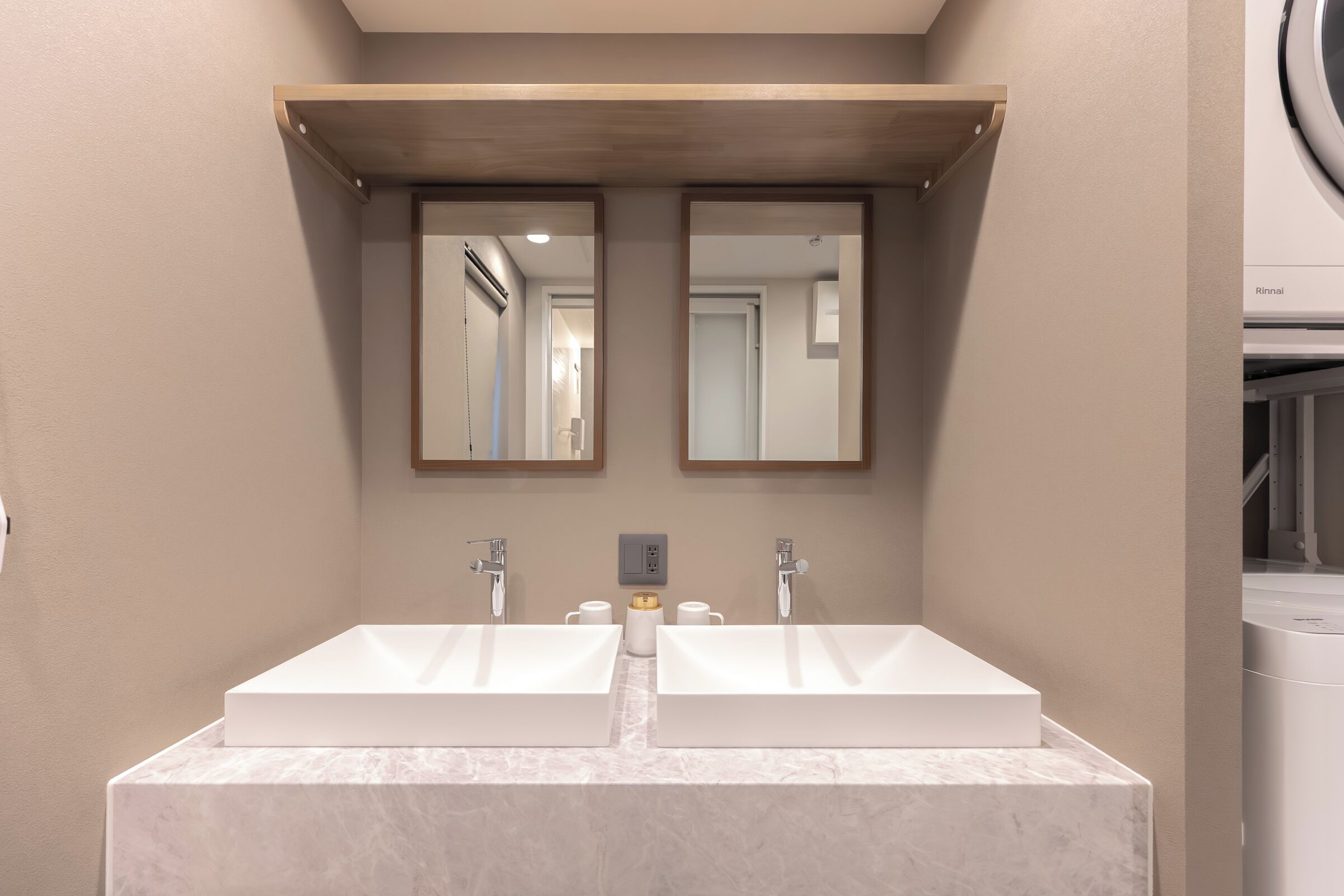A bathroom with two sinks, a mirror, and a shower area.