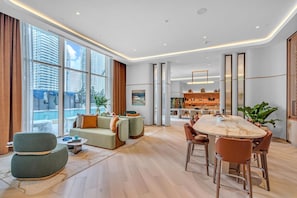 A modern hotel room with a dining area, large windows, and a view of high-rise buildings. - Exclusive 2BR in Brickell-Views & Top Amenities-Monthly Stay (Miami)