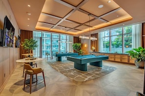 A pool table in a well-lit room with large windows, a bar area, and a seating arrangement. - Exclusive 2BR in Brickell-Views & Top Amenities-Monthly Stay (Miami)