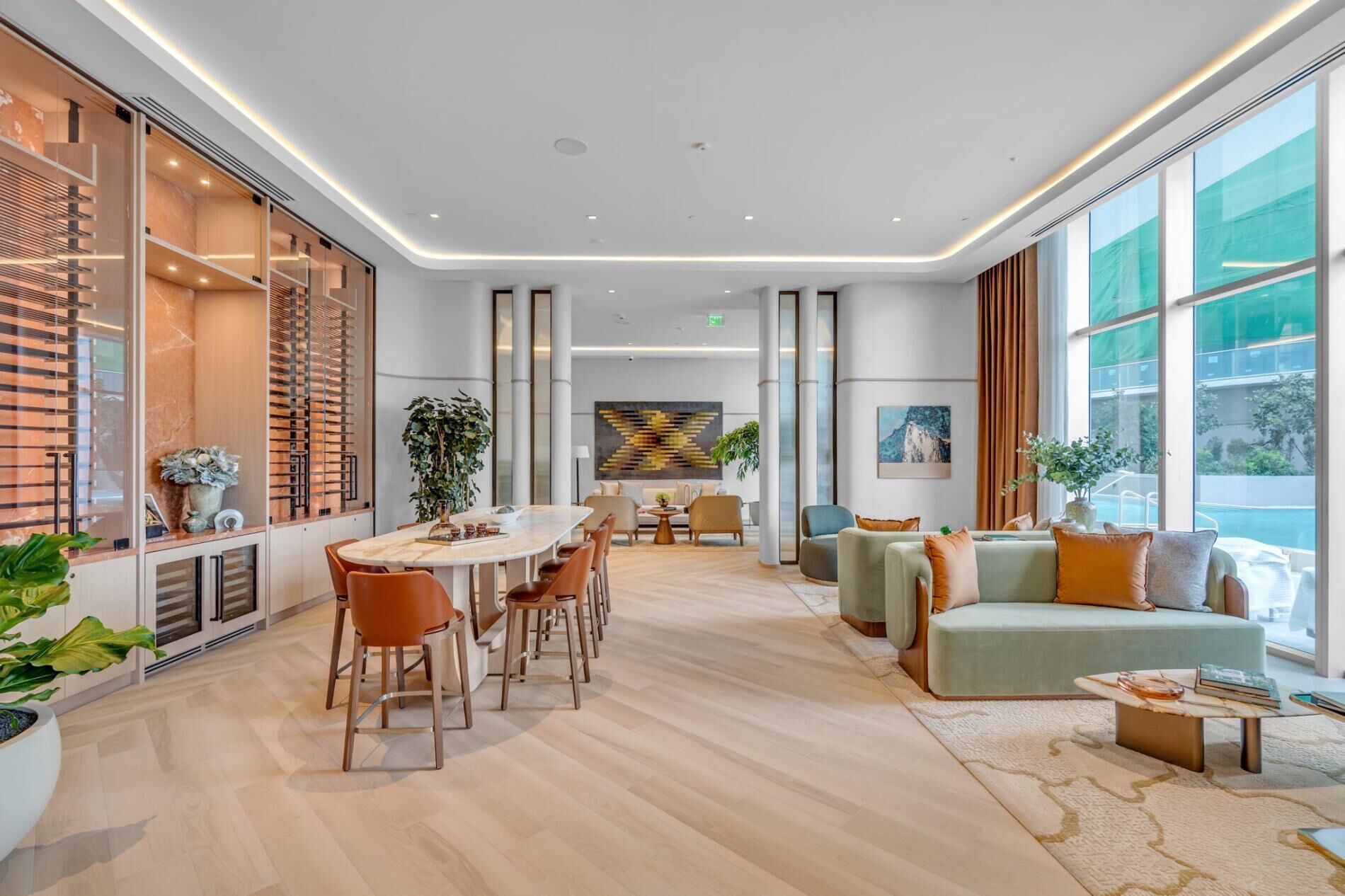 A modern hotel lobby with a central dining area, seating arrangements, and large windows offering views.