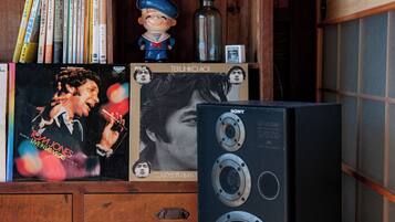A wooden cabinet with books, a figurine, and a large black speaker.