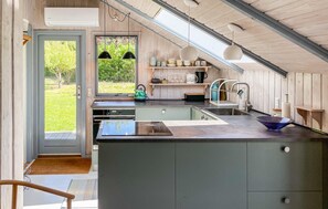 A modern kitchen with a large island, built-in appliances, and a view of the outdoors. - Beautiful home in Humble with WiFi (Humble)
