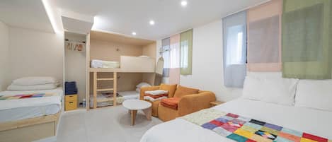 Et moderne soveværelse med en stor seng, en sofa, et lille bord og et walk-in closet.