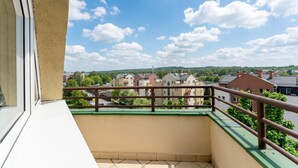 Un balcón con vista a edificios residenciales y un cielo despejado.