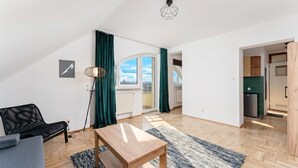 Un apartamento moderno con comedor, cocina y sala de estar con sofá y mesa.