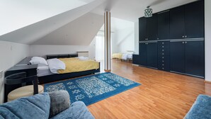 A modern bedroom with a loft bed, a large wardrobe, and a blue patterned rug. - Bielsko-Biała Serenity Apartment #1 (Bielsko-Biała)