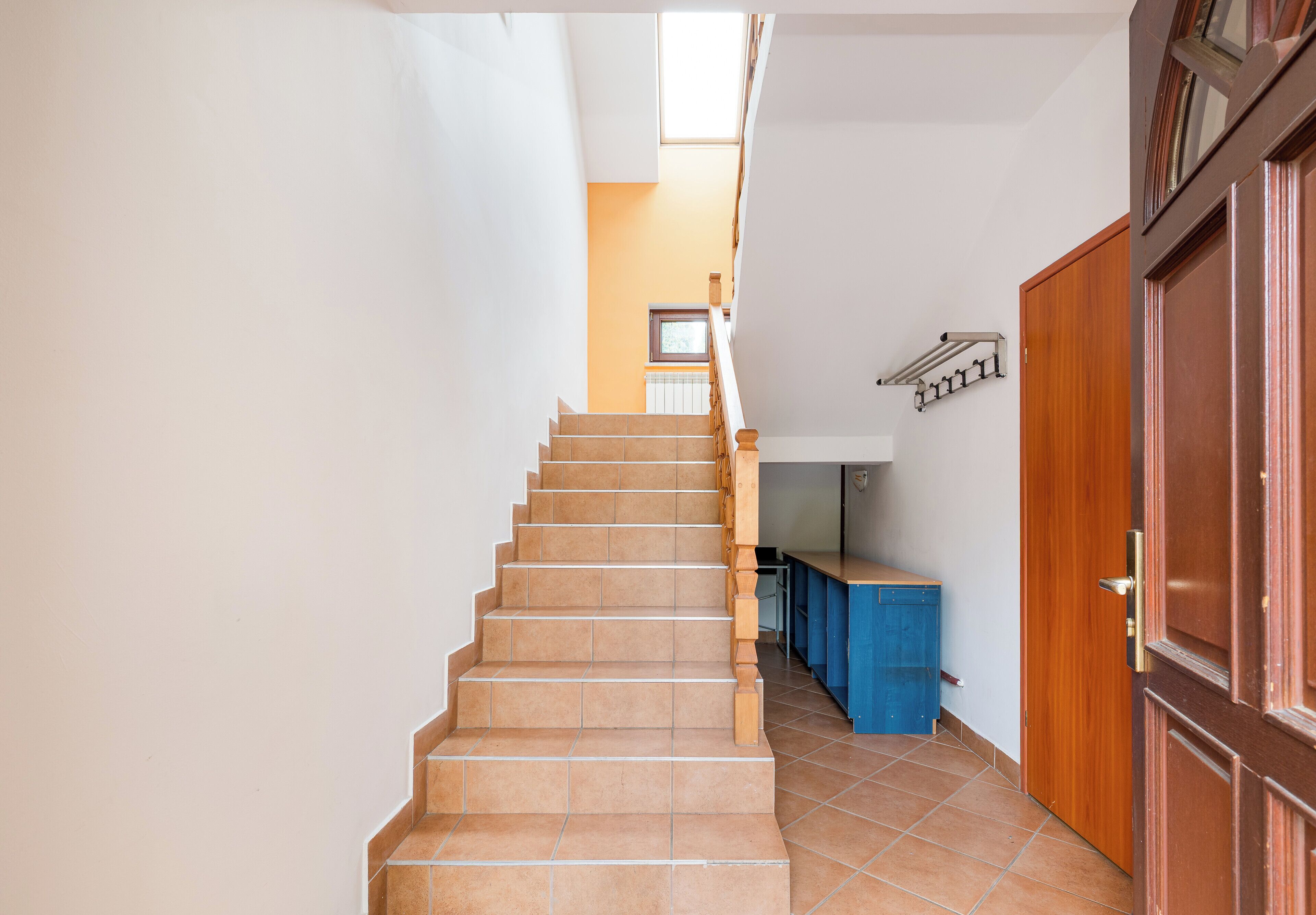 Una escalera que lleva a una plataforma con vista a una cocina.