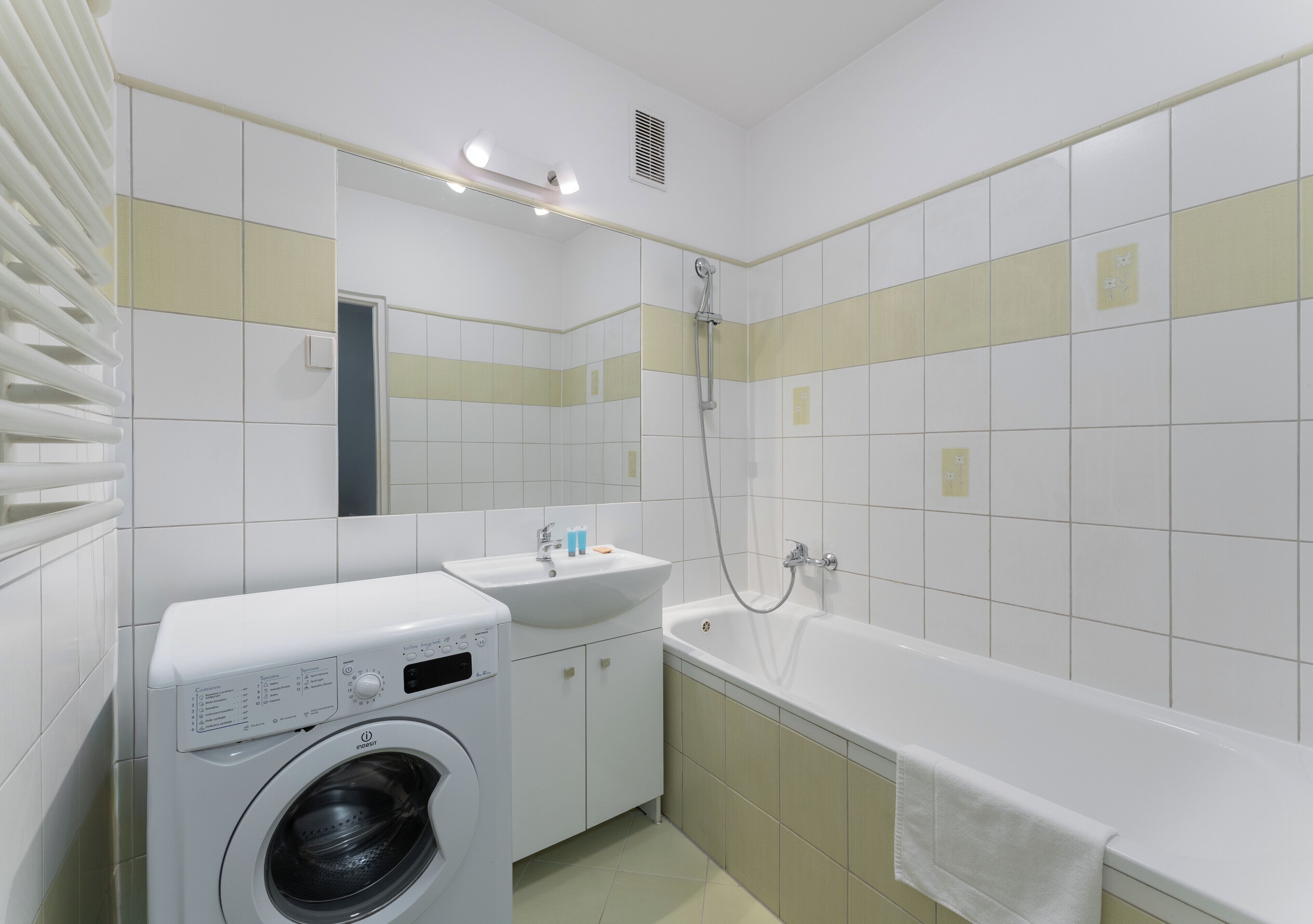 Un baño con lavadora, lavamanos y bañera.