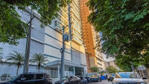 Un edificio de varios pisos con un estacionamiento al frente.
