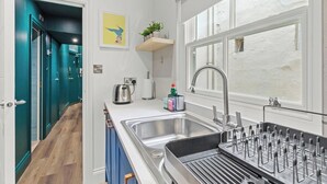 Une cuisine moderne équipée d’un évier, d’une bouilloire et d’un grille-pain.