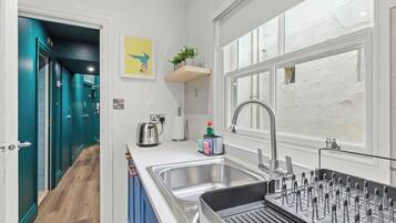 A modern kitchen with a sink, a kettle, and a toaster.