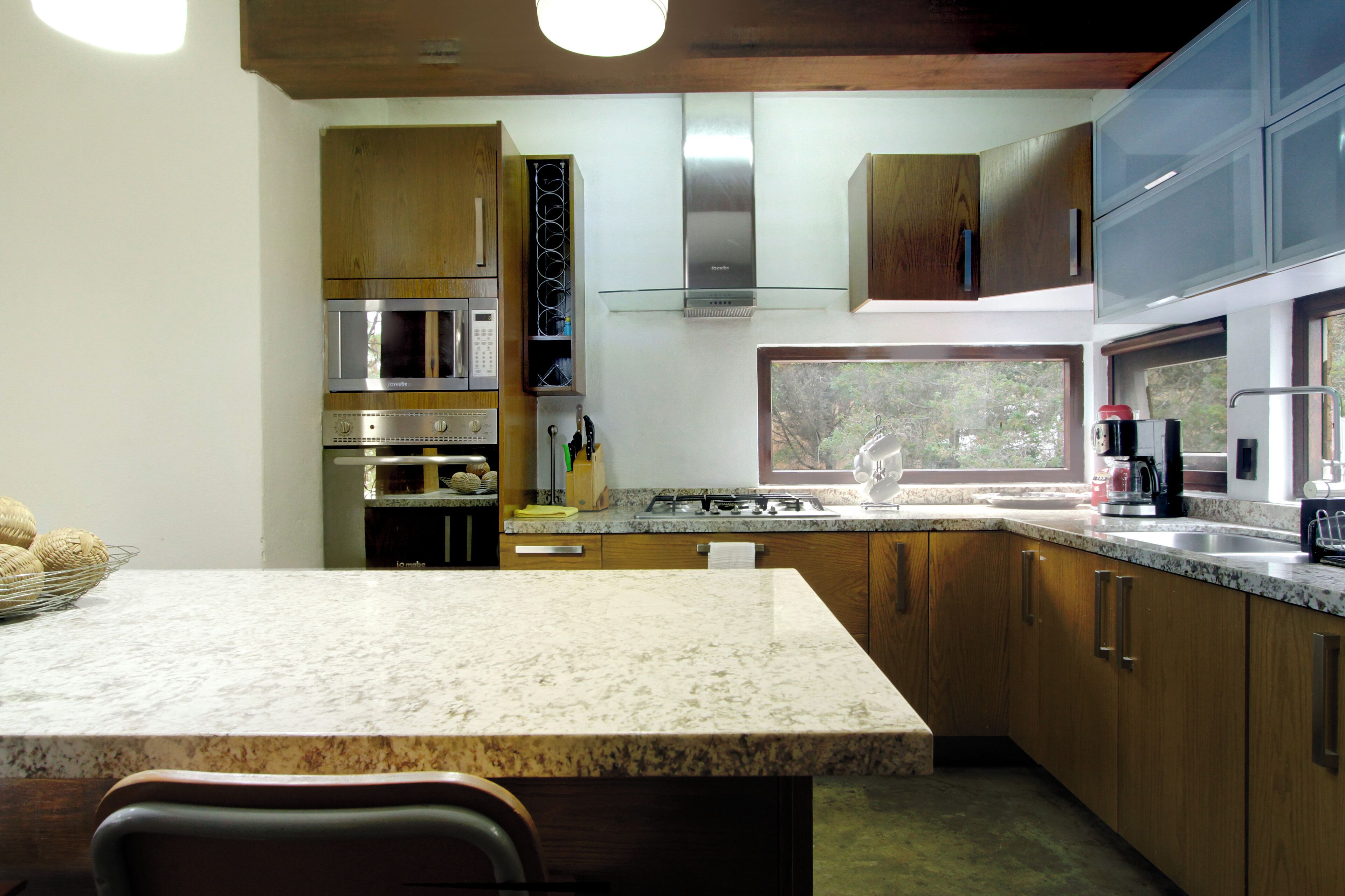 A kitchen with wooden cabinets, stainless steel appliances, and a large window.