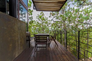 A wooden deck with a table and chairs, surrounded by a metal railing and overlooking a forest. - Family Cabin next to the Forest Tapalpa (Tapalpa)
