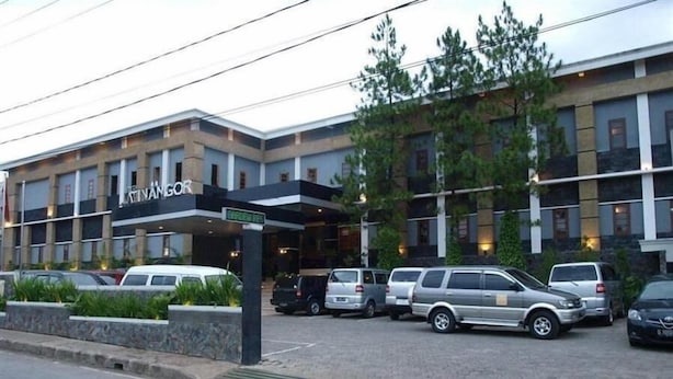 A hotel with a modern facade, multiple parking spaces, and a covered entrance. - Jatinangor Hotel Restaurant (Cileunyi)