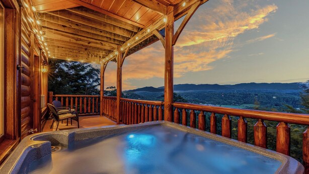 Ein Whirlpool auf einer Holzterrasse mit Blick auf die Berge.