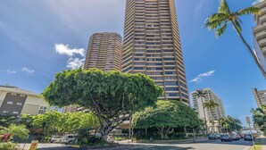 A high-rise building with multiple floors, surrounded by lush greenery and palm trees. - 28th Floor Ala Moana Suite | City + Mountain Views (Honolulu)
