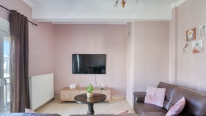 Ein Wohnzimmer mit Sofa, Couchtisch, Fernseher und Heizkörper.