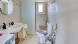 Ein modernes Badezimmer mit Waschbecken, Toilette und Duschbereich.